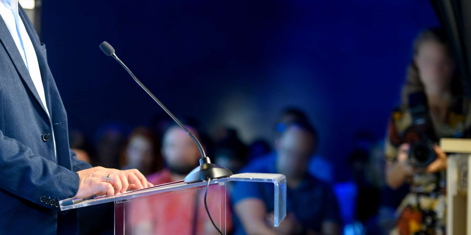 Iemand presenteert en staat achter een microfoon